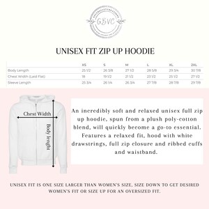 May include: White unisex zip-up hoodie with a relaxed fit, hood, and ribbed cuffs. The image includes a size chart with measurements in inches for body length, chest width, and sleeve length. The hoodie is made of a poly-cotton blend.