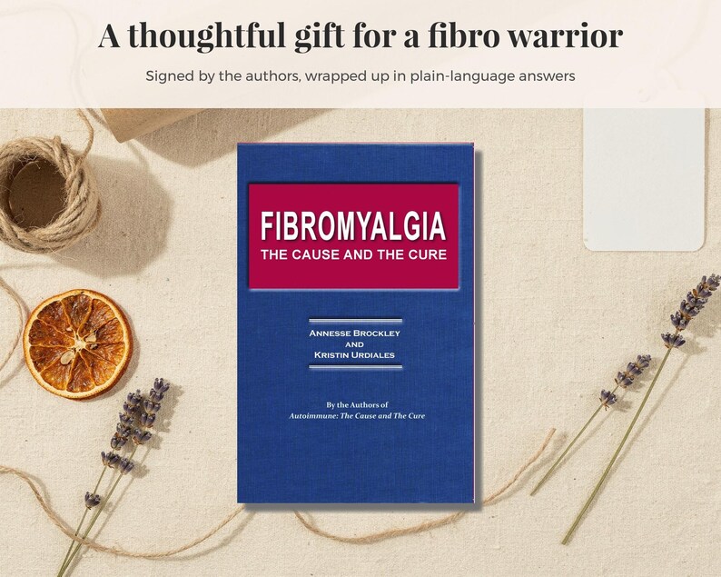 May include: A blue book titled Fibromyalgia The Cause and The Cure by Annesse Brockley and Kristin Urdiales. The cover features a red rectangular inset with white text. Above the book, the text reads A thoughtful gift for a fibro warrior.