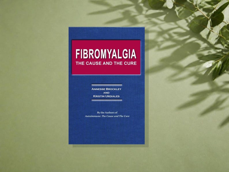 May include: A blue book titled Fibromyalgia: The Cause and The Cure by Annesse Brockley and Kristin Undiales. The cover features a red rectangular inset with white text and additional white text below, including the phrase By the Authors of Autoimmune: The Cause and The Cure.