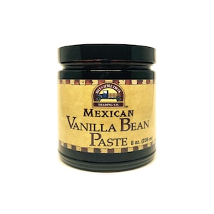 May include: A glass jar with a black lid containing Mexican Vanilla Bean Paste. The label is yellow with a red and white border and features a vintage truck logo. The label reads "Blue Cattle Truck Trading Co." and "Mexican Vanilla Bean Paste 8 oz. (236 ml)"