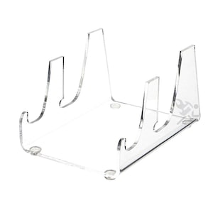 May include: A clear acrylic display stand with a rectangular base and curved supports. The stand has a minimalist design, suitable for showcasing various items. The transparent material allows for unobstructed viewing of displayed objects.