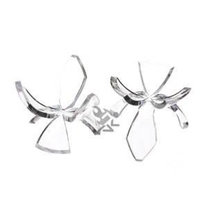 May include: Two clear acrylic sphere display stands. Each stand has a four-petal design with curved arms to cradle a sphere. The stands are transparent and sit on a white background.