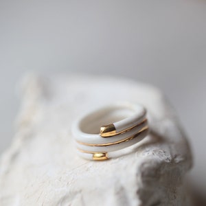 Substantiv, Ring aus weißem und goldenem Porzellan, emailliert. Keramischer Schmuck.