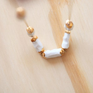 Cachoiera. Earth drop necklace in porcelain and gold.