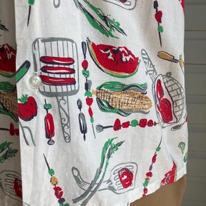 May include: White button-down shirt with a colorful barbecue-themed print. The pattern includes illustrations of grilled food, skewers, watermelon slices, and grilling utensils in red, green, and gray.