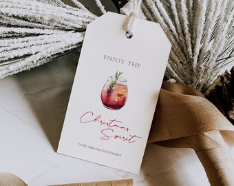 May include: A white gift tag with the text "Enjoy the Christmas Spirit" in red script. A watercolor illustration of a red cocktail with a sprig of rosemary is above the text. The text "Love, The Dalton Family" is below the illustration.