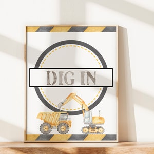 May include: A printable sign with a yellow, black and grey construction theme. The sign features a circle with a yellow and black dashed line border. The text "DIG IN" is in the centre of the circle. The sign also features a yellow dumper truck and a yellow excavator.