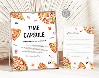Può includere: Un biglietto bianco con il testo "Time Capsule" e istruzioni per aprirlo quando Amelie compirà 18 anni. Il biglietto è decorato con fette di pizza, olive e peperoni rossi. È visibile anche un secondo biglietto con righe per scrivere una lettera.