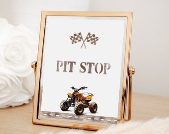 Pode incluir: Uma placa com moldura dourada, fundo branco e o texto "PIT STOP" em letras marrons. A placa também apresenta uma bandeira quadriculada em preto e branco, um ATV amarelo e uma estrada cinza.