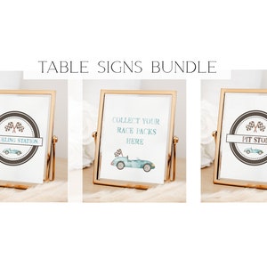 May include: Three gold-framed table signs with a racing car theme. The signs read "Refueling Station", "Collect Your Race Packs Here", and "Pit Stop".