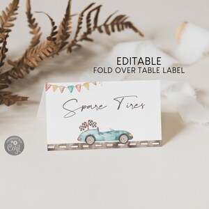 May include: Editable fold over table label with a blue car and the text "Spare Tires" in a handwritten font. The label has a colorful banner at the top and a gray road with white lines at the bottom.