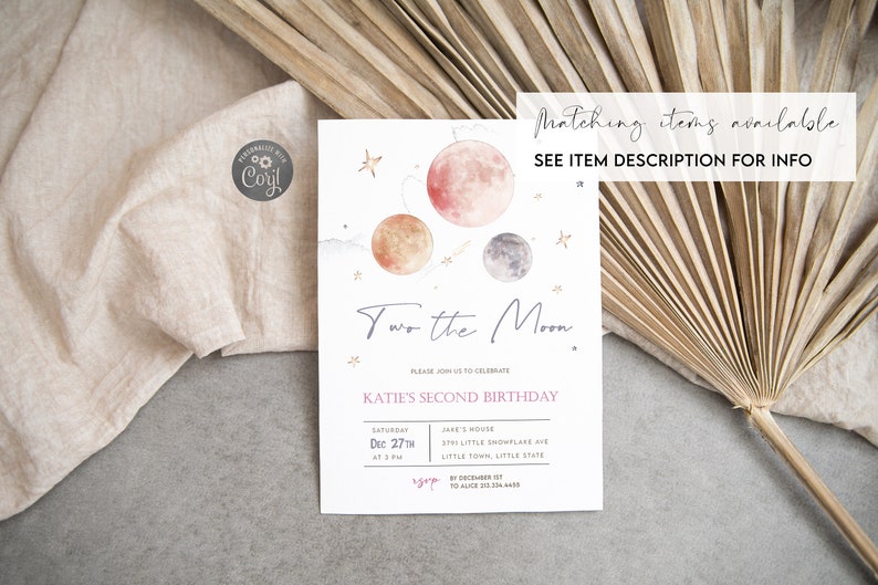 May include: A white invitation card with a watercolor illustration of planets and stars. The text reads "Two the Moon" and "Katie's Second Birthday". The invitation includes details for the birthday party, including the date, time, and location.