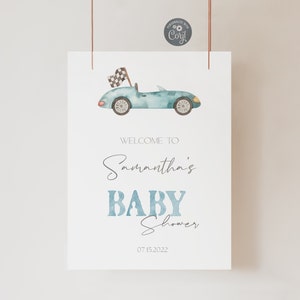 May include: A blue and white baby shower welcome sign with a cartoon blue car and checkered flag. The sign says "Welcome to Samantha's Baby Shower 07.15.2022".