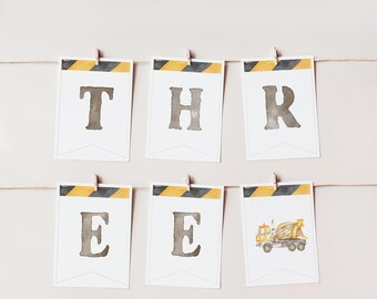 May include: A construction-themed banner with yellow and black striped flags. The flags spell out "THREE" with a cement mixer truck graphic on the last flag.