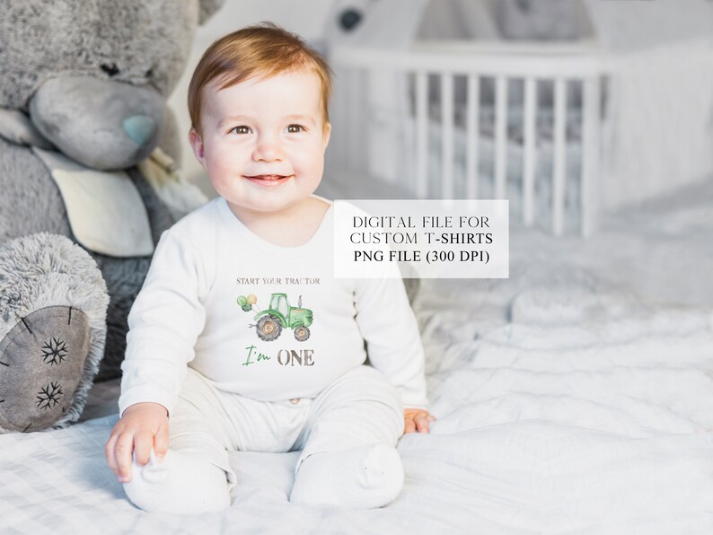 May include: A baby boy wearing a white onesie with a green tractor and the text "Start your tractor I'm one" printed on it. The baby is sitting on a white bed with a gray teddy bear beside him.