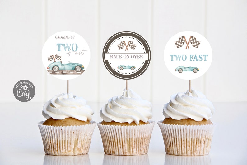 May include: Three cupcake toppers with a racing car theme. The toppers are round and white with blue and brown accents. The text on the toppers reads "Growing Up Two Fast", "Race On Over", and "Two Fast".