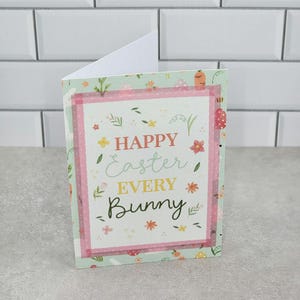 May include: A light green and pink card with a white border and a floral pattern. The card says "Happy Easter Every Bunny".