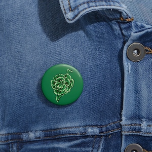 May include: A green button with a green and white carnation flower design.