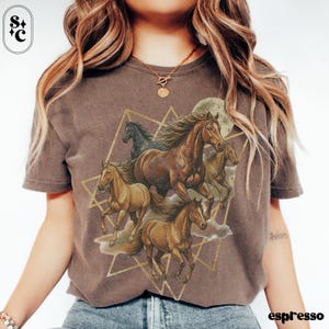 May include: Espresso-coloured t-shirt with a graphic of running horses in shades of brown and tan, set against a full moon and geometric shapes. The design includes a black horse and the word "espresso" at the bottom.