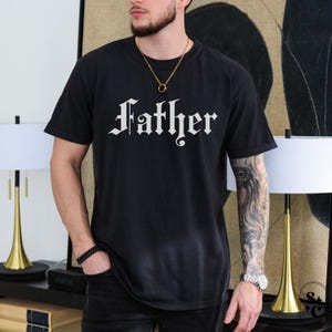 May include: Black t-shirt with the word "Father" printed in white in a gothic font.
