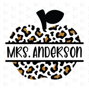 Puede incluir: Una manzana de estampado de leopardo negro y marrón con un tallo y una hoja negros. El texto "MRS. ANDERSON" está escrito en negro sobre una pancarta blanca en el medio de la manzana.