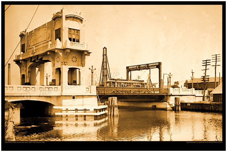 May include: A vintage black and white photograph of a drawbridge over a canal. The bridge is raised, allowing a streetcar to pass through. The bridge is made of metal and has a wooden deck. The streetcar is a vintage model with wooden seats and windows. The photograph is taken from a low angle, looking up at the bridge.