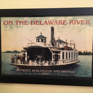 May include: A vintage poster depicting a ferry boat named "William Doro" on the Delaware River between Burlington and Bristol in 1909. The poster features a colorful illustration of the ferry boat with passengers on board.