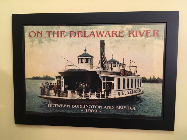 May include: A vintage poster depicting a ferry boat named "William Doro" on the Delaware River between Burlington and Bristol in 1909. The poster features a colorful illustration of the ferry boat with passengers on board.