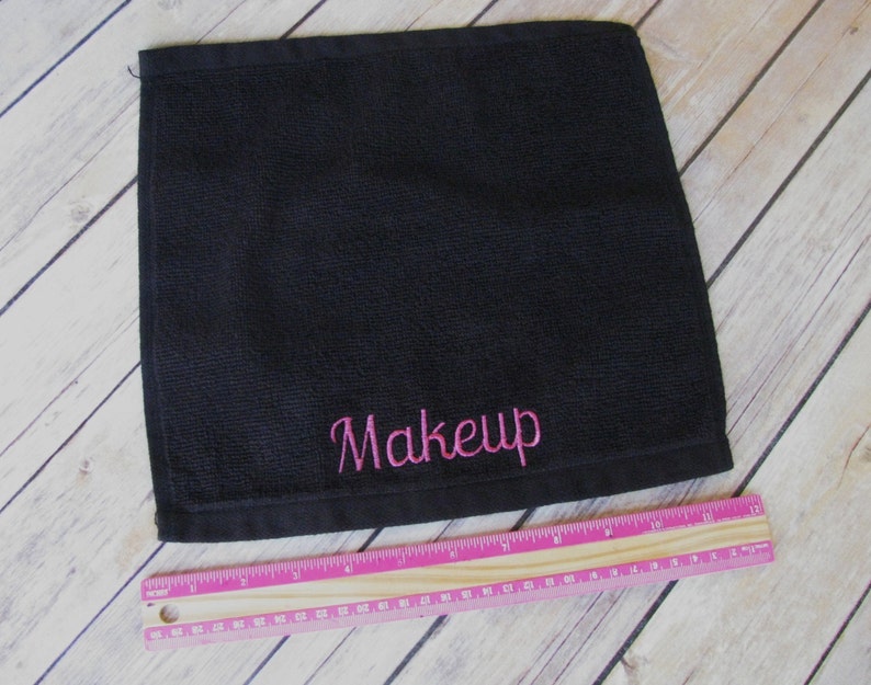 May include: Black cotton makeup remover towel with pink embroidery that says "Makeup".