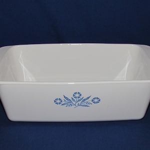 May include: White rectangular baking dish with a blue floral design. The dish has a slightly flared rim and is made of a durable material. A classic piece for baking and serving.