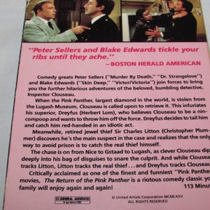 May include: The back of a VHS tape for "The Return of the Pink Panther" movie. The pink background features text about the film's plot, cast, and critical acclaim. The top of the tape shows a scene from the movie.