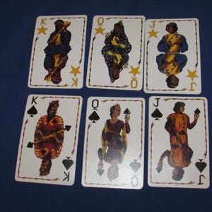 May include: Six playing cards featuring illustrations of kings, queens, and jacks. The cards have a white background with decorative borders and suit symbols. The figures are depicted in colorful, historical attire, with stars and suit symbols.