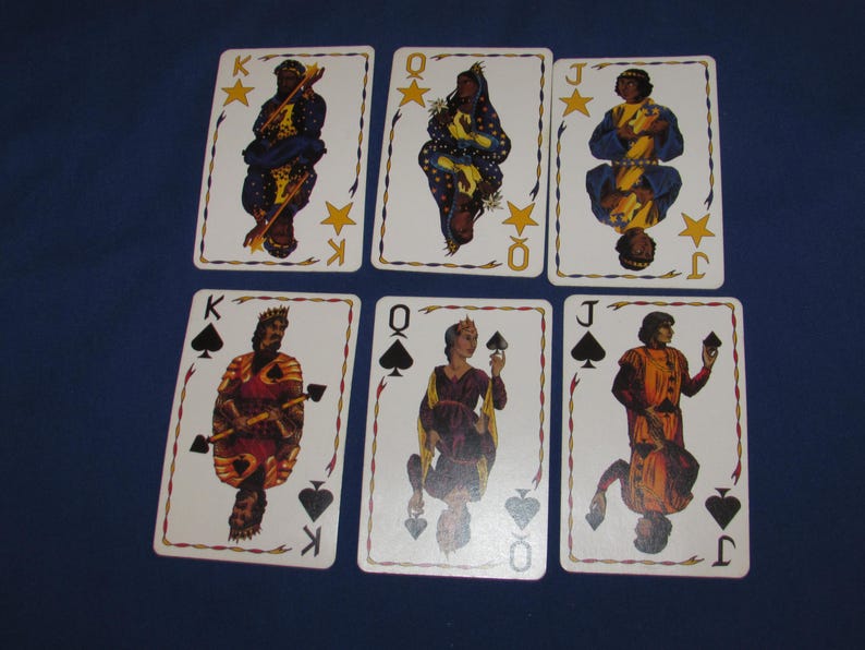 May include: Six playing cards featuring illustrations of kings, queens, and jacks. The cards have a white background with decorative borders and suit symbols. The figures are depicted in colorful, historical attire, with stars and suit symbols.