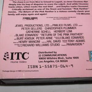 May include: A pink VHS tape for "The Return of the Pink Panther" movie. The cover features the film's title and credits, including Peter Sellers and Blake Edwards. The tape is distributed by J2 Communications.