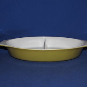 May include: A divided oval baking dish with a white interior and a yellow exterior.