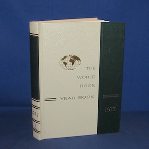 May include: A white book with a green spine. The book is titled "The World Book Year Book 1977".