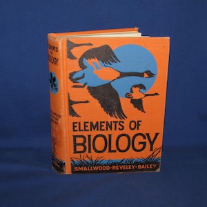May include: An orange book titled "Elements of Biology" with a blue and black illustration of flying geese. The book's cover also features the names "Smallwood, Reveley, Bailey". The book is standing upright.