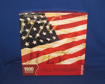 May include: A 1500 piece jigsaw puzzle featuring a close-up of an American flag with the text "Declaration of Independence of the United States of America" and "4th, 1776" and the words "Call to Freedom".