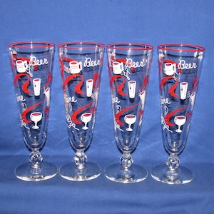 May include: Four clear beer glasses with red rims and decorative red swirls. Each glass features the word "Beer" and illustrations of beer mugs, glasses, and goblets. The glasses have a classic, vintage design.