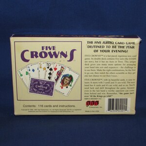 May include: A Five Crowns card game box with the game title in purple and white. The box displays playing cards with various suits and values. The text on the box reads "The Five Suited Card Game Destined to be the Star of Your Evening!"