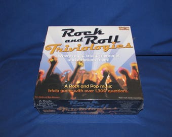 May include: A square board game box titled Rock and Roll Triviologies. The white cover features a graphic of a concert crowd with raised hands, blue sunburst rays, and text stating: Where music, trivia, memories and emotions meet! A Rock and Pop music trivia game with over 1,300 questions.