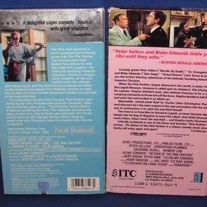 May include: Two VHS video cassette tapes for the movie "The Return of the Pink Panther." The tapes have colorful labels with movie details, cast, and reviews. The background is a blue surface.