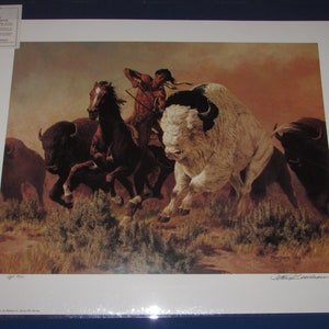 May include: A vintage print of a Native American on horseback chasing a white buffalo with a herd of brown buffalo in the background. The print is titled "The Last Stand" and signed by the artist.