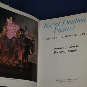 May include: A book titled "Royal Doulton Figures" with a photo of a porcelain figurine of a woman riding an elephant. The book cover text states "Produced at Burslem c1890-1978" and "Desmond Eyles & Richard Dennis".