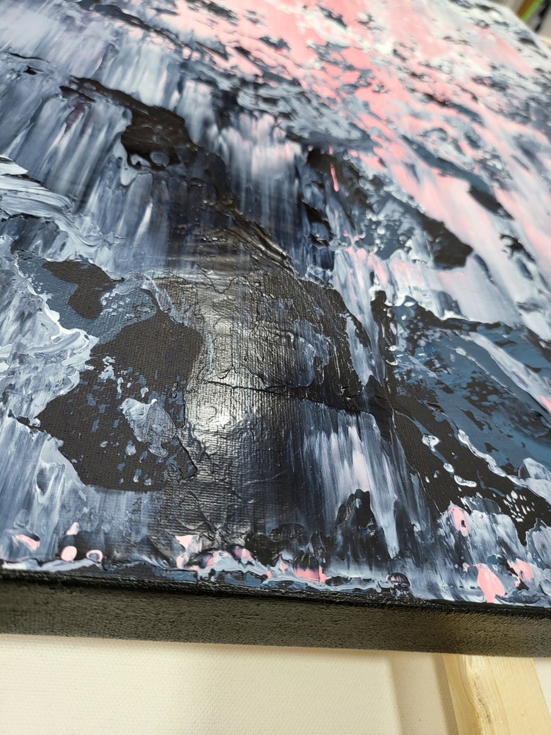 May include: Abstract painting on canvas with a black, white, pink, and blue color scheme. The paint is applied in thick layers, creating a textured surface.