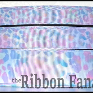 May include: Three rolls of white satin ribbon with a light blue, pink, and green tie-dye pattern and a white leopard print. The ribbon is 1.5 inches wide and is perfect for crafting, gift wrapping, and hair bows. The ribbon is sold by the yard.