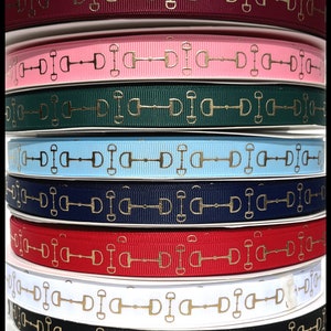 May include: Assortment of 10 spools of gold equestrian-themed ribbon. The ribbon is in various colors including burgundy, pink, green, light blue, navy blue, red, white, and black. The ribbon features a gold equestrian bit design.