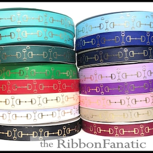 May include: Assortment of 10 spools of gold-colored equestrian-themed ribbon. The ribbon is in various colors, including teal, green, red, ivory, black, pink, beige, and burgundy. The ribbon features a repeating pattern of gold-colored horse bits.