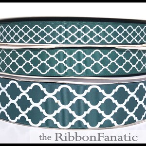 May include: Three spools of green and white patterned ribbon. The pattern is a white trellis design on a dark green background. The ribbon is on a white background.
