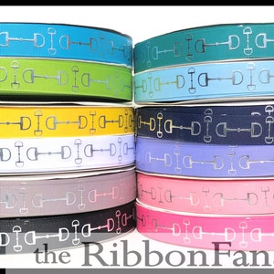 May include: A collection of 10 rolls of equestrian-themed ribbon with a silver snaffle bit design. The ribbon is available in a variety of colors, including teal, green, yellow, white, gray, black, blue, lavender, pink, and red.